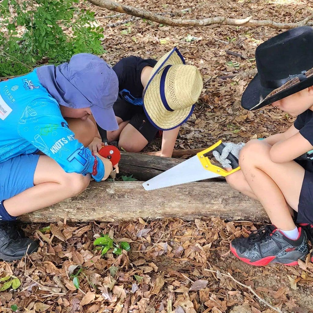 Kids using woodwork tools in the outdoors