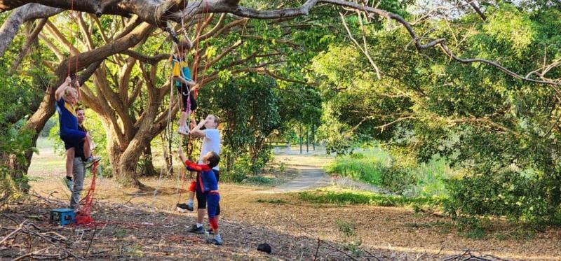 Children engaging in nature‑based play outdoors among trees as part of occupational therapy activities.